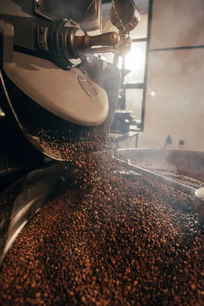 Vista de cerca de granos de café tostado en la máquina - foto de stock