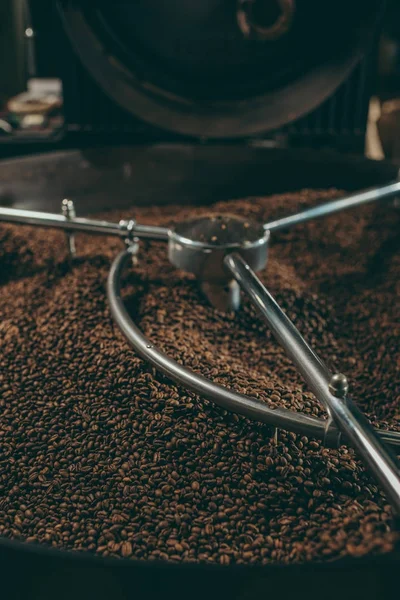 Vista de cerca de granos de café tostado en la máquina — Stock Photo