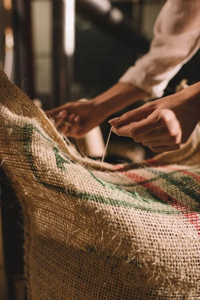 Visão parcial do trabalhador amarrando saco saco com grãos de café — Fotografia de Stock