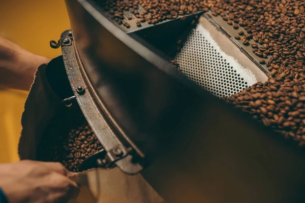 Vista parcial del tostador de café trabajando en la máquina de tostado - foto de stock