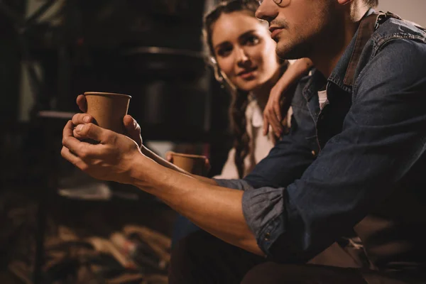 Partial view of couple with cups of coffee having break during work at coffee shop — Stock Photo