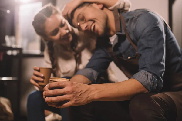 Selective focus of couple with cups of coffee having break during work at coffee shop — Stock Photo