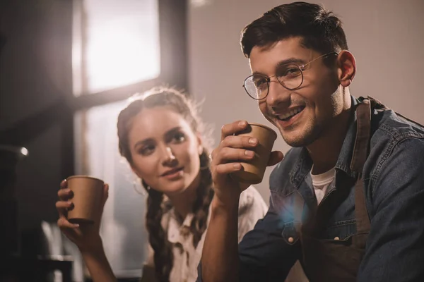 Coppia con tazze di caffè che ha la pausa durante lavoro a caffetteria — Foto stock