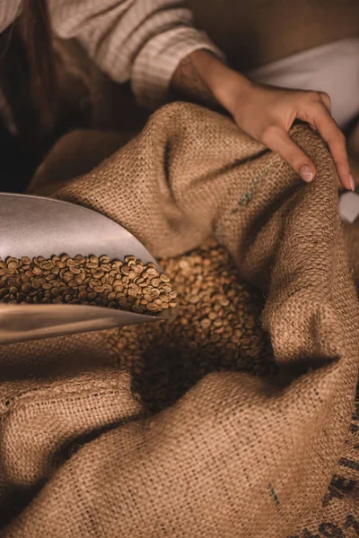 Vue partielle du travailleur ramassant des grains de café avec une cuillère en métal du sac à dos — Photo de stock