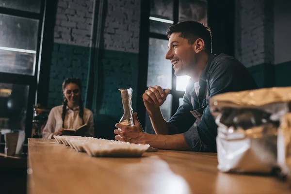 Jeunes collègues debout à la table en bois dans un café — Photo de stock