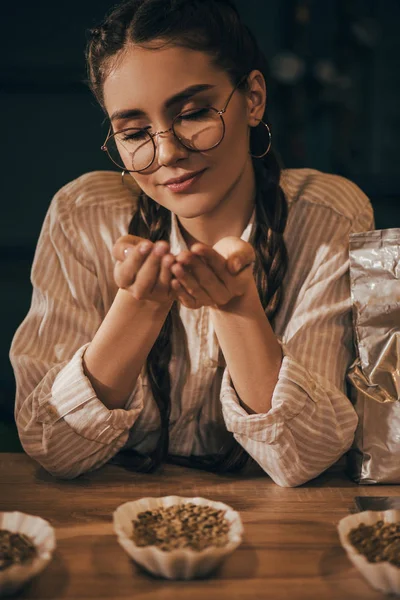 Portrait de jeune femme tenant des grains de café dans les mains — Photo de stock