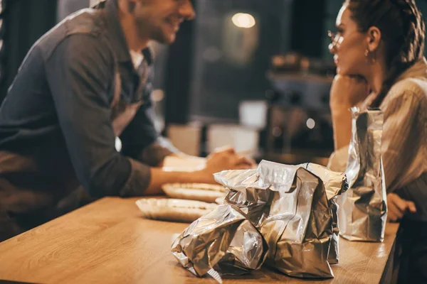 Enfoque selectivo de los colegas que tienen conversación en la mesa en la chuleta de café - foto de stock