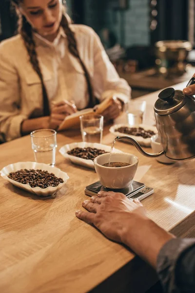 Messa a fuoco selettiva dell'uomo versando acqua calda nella ciotola con macinare il caffè — Foto stock