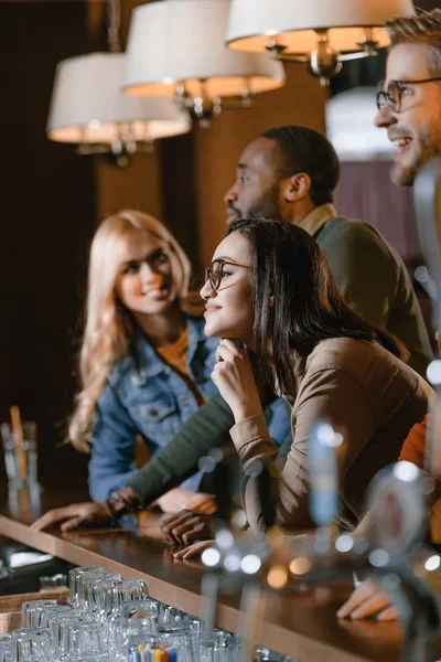 Cheerful young attractive friends at bar — Stock Photo