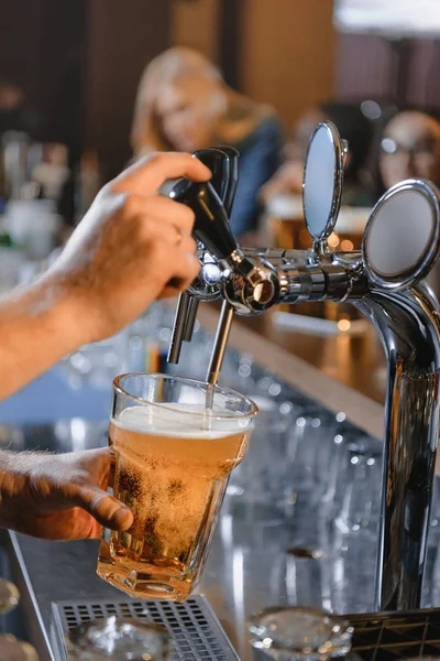 Immagine ritagliata di barman versando birra in vetro al bar — Foto stock