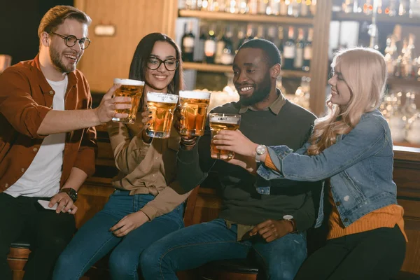 Allegri amici multiculturali che bevono birra insieme al bar — Foto stock