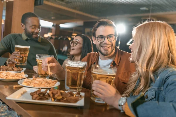 Attractive multiculture friends eating and drinking at bar — Stock Photo