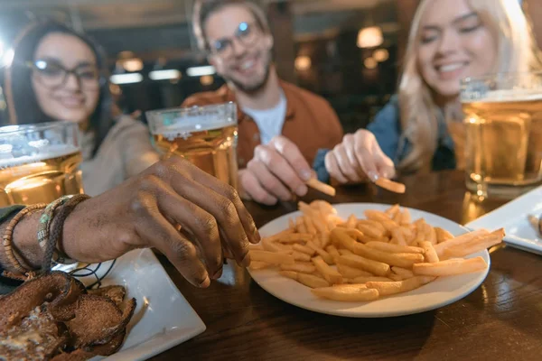 Joven empresa multicultural comer y beber en el bar - foto de stock