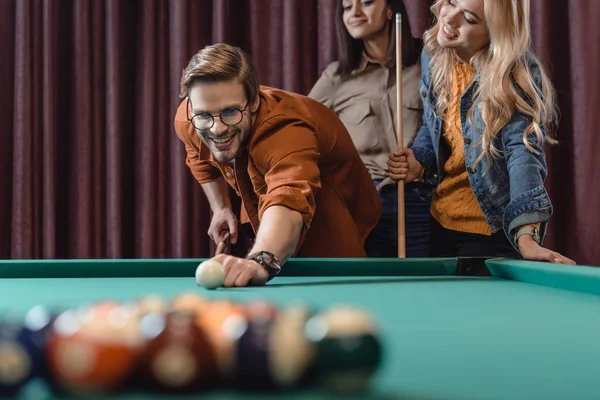 Homem bonito jogando na piscina no bar com meninas — Fotografia de Stock