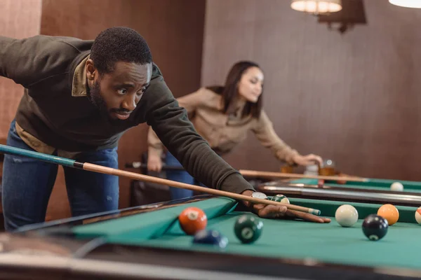 Afrikanisch-amerikanischer Mann spielt in Pool an Bar mit Freunden — Stockfoto