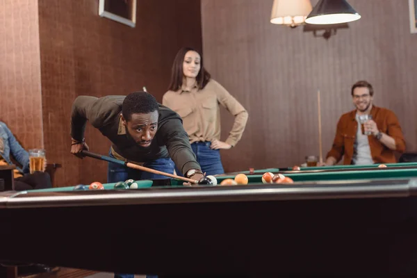 Afro-americano homem jogar na piscina no bar com amigos — Fotografia de Stock