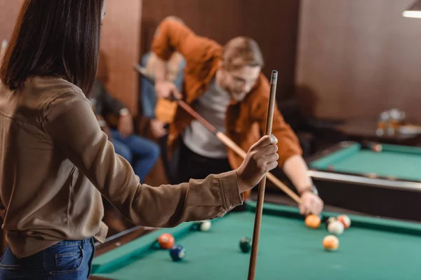 Back view of girl with cue infront of gambling pool table — Stock Photo