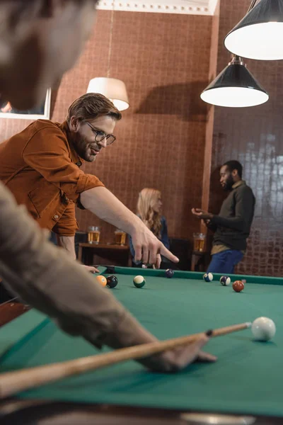 Imagen recortada de jóvenes amigos multiétnicos jugando en la piscina en el bar - foto de stock