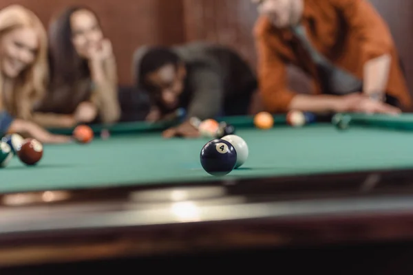 Junge multiethnische Freunde spielen in Pool an Bar — Stockfoto
