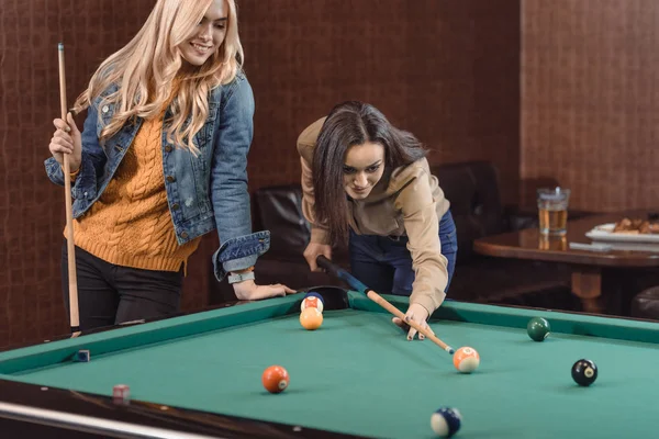 Dos chicas jóvenes jugando en la piscina en el bar - foto de stock