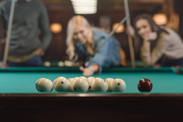 Молодые многонациональные друзья играют в бильярд в баре — стоковое фото