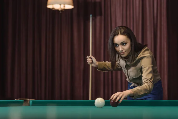 Pretty young girl playing in pool at bar — Stock Photo
