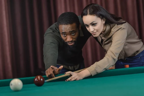 Junge attraktive multiethnische Mann und Frau spielen in Pool an der Bar — Stockfoto