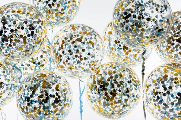 Grandes balões com confete dourado e azul e estrelas, isolados em branco — Fotografia de Stock