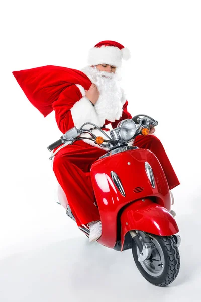 Santa Claus with big red bag sitting on red scooter, isolated on white — Stock Photo