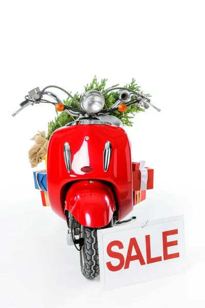 Arbre de Noël et cadeaux sur scooter rouge avec signe de vente, isolé sur blanc — Photo de stock