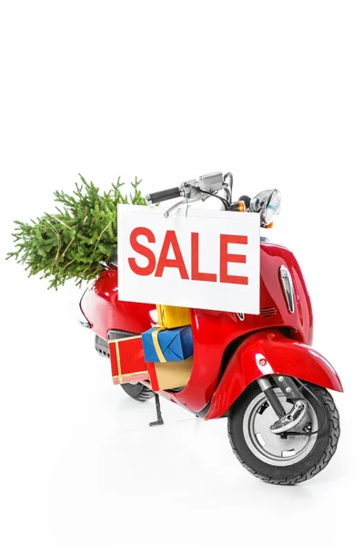 Рождественская елка и подарочные коробки на красном скутере с табличкой продажи, изолированные на белом — стоковое фото