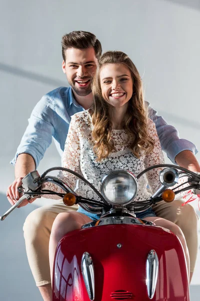 Portrait of happy couple in love riding red scooter together — Stock Photo