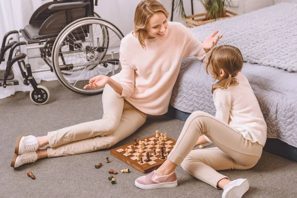 Mãe com deficiência e filha jogando xadrez — Fotografia de Stock