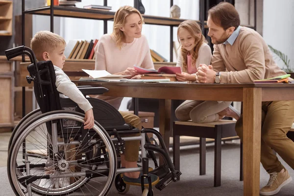 Happy parents teaching children at home — Stock Photo