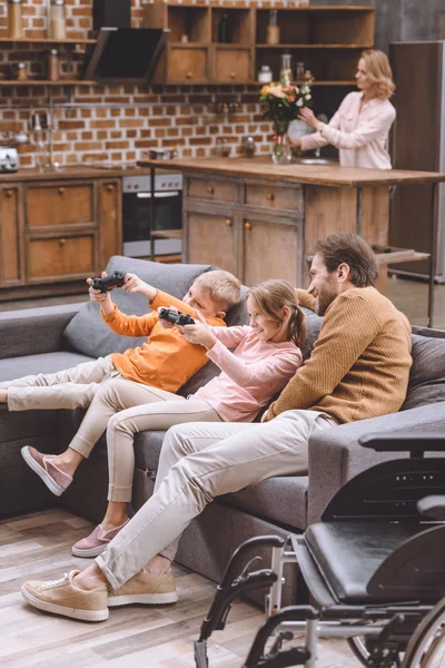 Souriant père regarder comment les enfants jouer jeu vidéo — Photo de stock