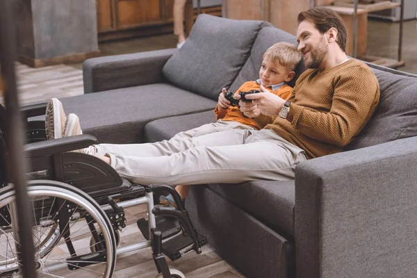 Felice padre e figlio giocare al videogioco con pastiglie di gioco — Foto stock