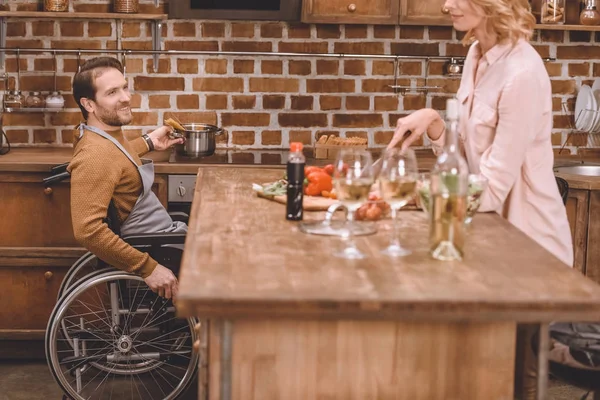 Cropped shot of woman with man in wheelchair cooking dinner together at home — Stock Photo