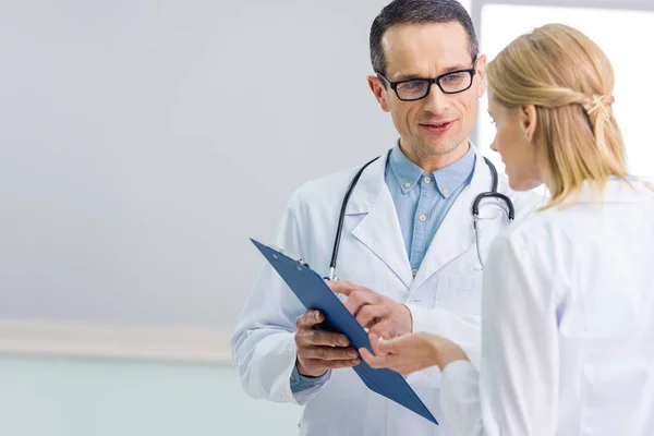 Deux médecins en blouse blanche discutant du diagnostic à l'hôpital — Photo de stock