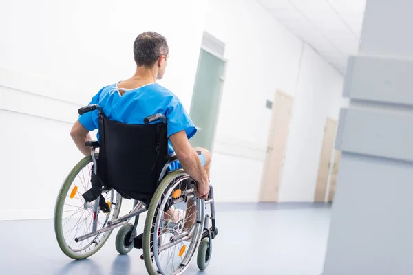 Vista posterior del paciente masculino en silla de ruedas en el hospital - foto de stock