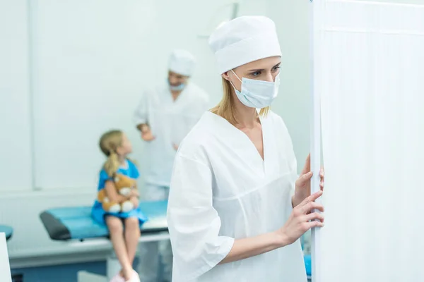 Médicos que preparan al niño para la cirugía en quirófano - foto de stock