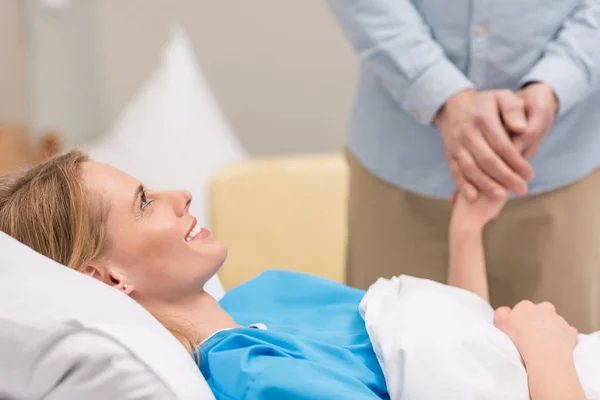 Cropped image of husband holding hands with sick wife — Stock Photo