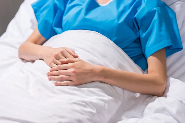 Обрезанное изображение больной женщины лежащей на больничной койке — стоковое фото