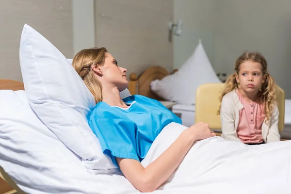 Засмучена дочка дивиться на хвору матір в лікарні — стокове фото