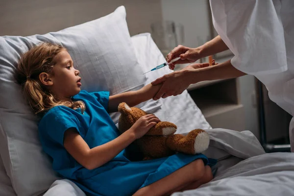 Immagine ritagliata del medico femminile che fa la vaccinazione al bambino spaventato — Foto stock