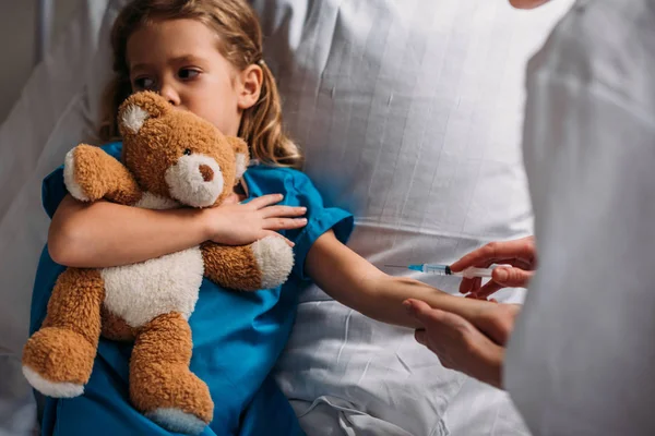 Imagen recortada de la doctora haciendo la vacunación al paciente del cabrito - foto de stock