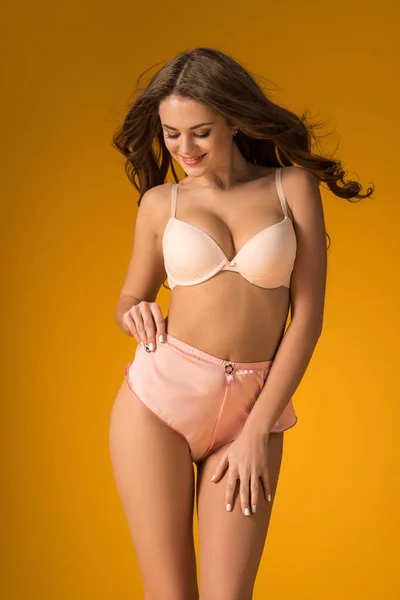Sexy girl posing in lingerie set isolated on orange — Stock Photo