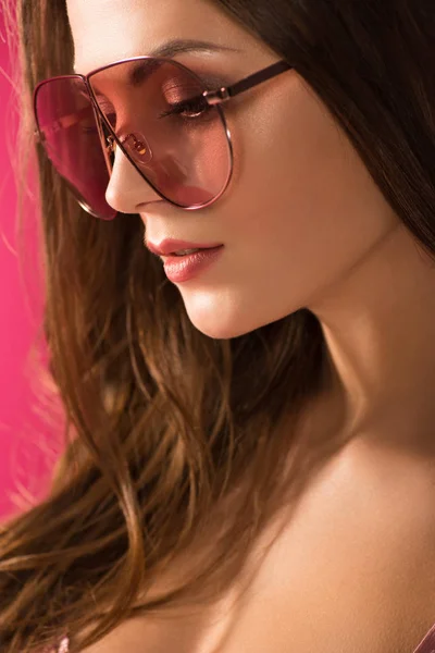 Портрет привабливої дівчини в сонцезахисних окулярах ізольовано на рожевому — стокове фото