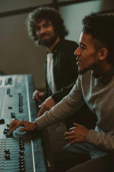 Concentrated young sound producers at recording studio — Stock Photo