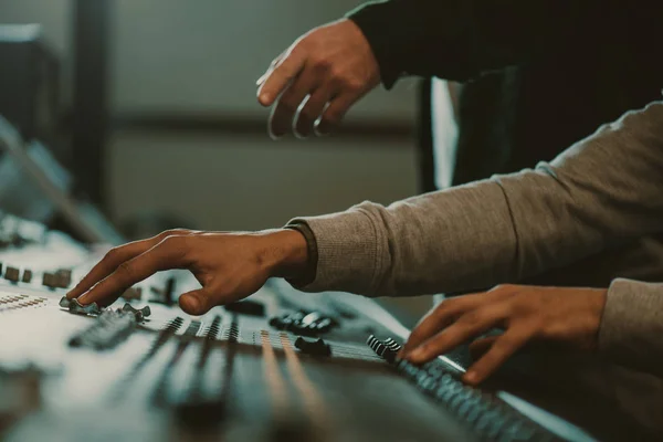 Cropped shot of men using analog graphic equalizer at recording studio — Stock Photo