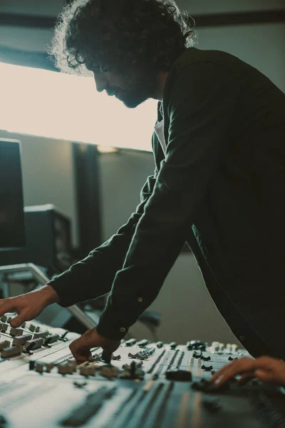 Apuesto joven productor de sonido trabajando con el equipo de grabación - foto de stock